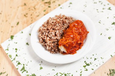 karabuğday balık sosları ile yeşillik serpilir hafif ahşap arka plan üzerinde beyaz kesme tahtası üzerinde beyaz bir tabakta altında