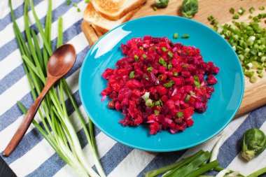 salata pancar, sarımsak, yeşil soğan ve Brüksel lahanası ahşap kesme tahtası üzerinde bir kase ile mutfak havlusu koyu ahşap zemin çizgili