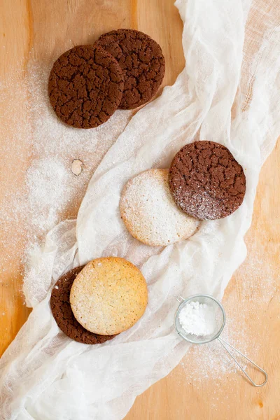 Okrągłe dużych plików cookie na biały obrus na jasnym tle drewnianych posypane cukrem w proszku — Zdjęcie stockowe