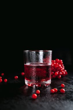 Kırmızı kokteyl ile kırmızı meyveler, buğulu cam siyah ıslak zemin kadar