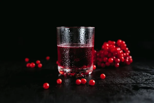Cocktail rosso con bacche rosse, vetri appannati su fondo nero bagnato — Foto Stock