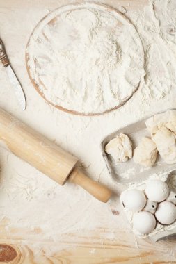 yumurta, un, hamur, oklava ve hafif ahşap arka plan üzerinde yuvarlak ahşap tahta