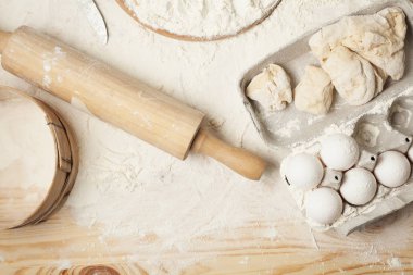 yumurta, un, hamur, oklava ve hafif ahşap arka plan üzerinde yuvarlak ahşap tahta
