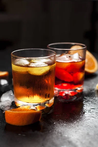 Dwie szklanki z koktajle z lodem z orange na mokro ciemnym tle — Zdjęcie stockowe