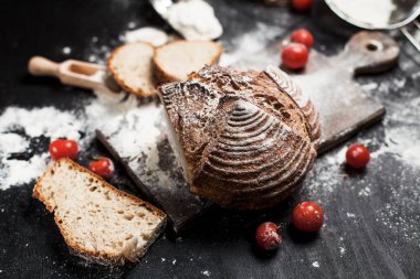 Fırından yeni çıkmış ekmek, un ve bir ahşap tahta bir tablo üzerinde domates