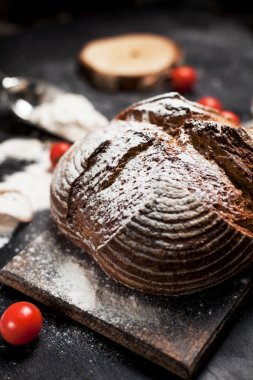 Fırından yeni çıkmış ekmek, un ve bir ahşap tahta bir tablo üzerinde domates