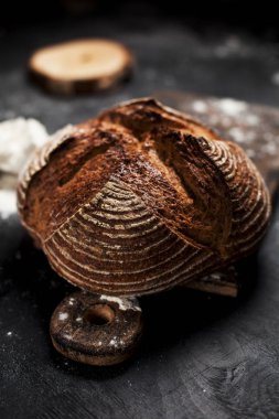 Fırından yeni çıkmış ekmek, un ve bir ahşap tahta bir tablo üzerinde domates