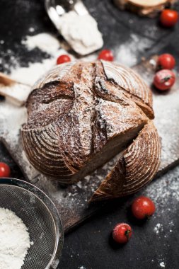 Fırından yeni çıkmış ekmek, un ve bir ahşap tahta bir tablo üzerinde domates