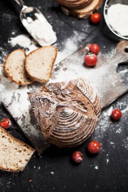 Fırından yeni çıkmış ekmek, un ve bir ahşap tahta bir tablo üzerinde domates