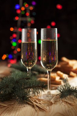 Şampanya, bisküvi, bir Noel ağacı ve bir yeni yıl Festival tablo yılbaşı ışıkları ile gözlük