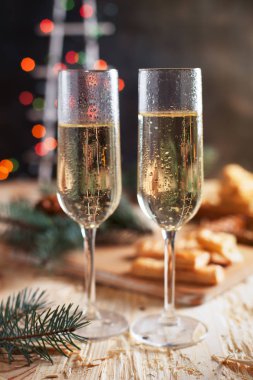Şampanya, bisküvi, bir Noel ağacı ve bir yeni yıl Festival tablo yılbaşı ışıkları ile gözlük