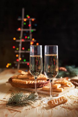 Şampanya, bisküvi, bir Noel ağacı ve bir yeni yıl Festival tablo yılbaşı ışıkları ile gözlük