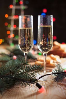 Şampanya, bisküvi, bir Noel ağacı ve bir yeni yıl Festival tablo yılbaşı ışıkları ile gözlük