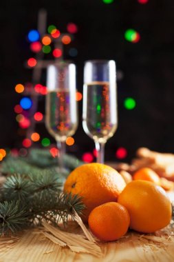 Şampanya, mandalina, bisküvi, bir Noel ağacı ve bir yeni yıl Festival tablo yılbaşı ışıkları ile gözlük