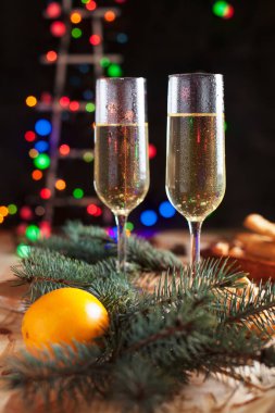 Şampanya, mandalina, bisküvi, bir Noel ağacı ve bir yeni yıl Festival tablo yılbaşı ışıkları ile gözlük