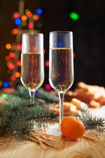 Verres avec champagne, mandarines, biscuits, sapin de Noël et lumières du Nouvel An sur une table de fête du Nouvel An — Photo