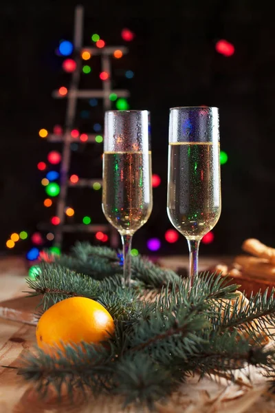 Şampanya, mandalina, bisküvi, bir Noel ağacı ve bir yeni yıl Festival tablo yılbaşı ışıkları ile gözlük