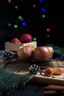 Yeni yıl, çam ağacı, koniler, siyah bir arka plan üzerinde yeni yıl ışıklar için pişmiş elma