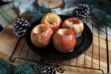 Yeni yıl, çam ağacı, koniler, pişmiş elma tatlım siyah bir arka plan üzerinde