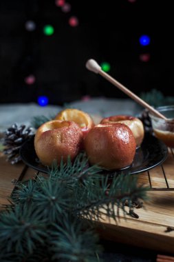 Yeni yıl, çam ağacı, koniler, tatlım yılbaşı ışıkları siyah bir zemin üzerine pişmiş elma