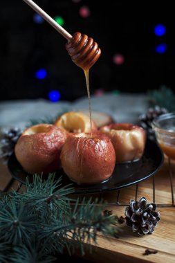 Yeni yıl, çam ağacı, koniler, tatlım yılbaşı ışıkları siyah bir zemin üzerine pişmiş elma