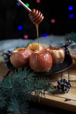 Yeni yıl, çam ağacı, koniler, tatlım yılbaşı ışıkları siyah bir zemin üzerine pişmiş elma