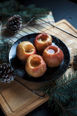 Yeni yıl, çam ağacı, koniler, pişmiş elma tatlım siyah bir arka plan üzerinde