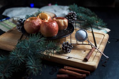 Yeni yıl, çam ağacı, koniler, pişmiş elma tatlım siyah bir arka plan üzerinde