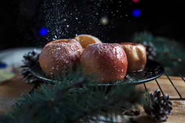 Yeni yıl, çam ağacı, koniler, siyah bir arka plan üzerinde yeni yıl ışıklar için pişmiş elma