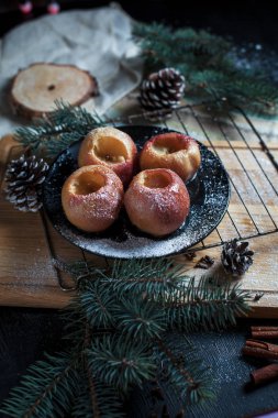 Yeni yıl, çam ağacı, koniler, pişmiş elma tatlım siyah bir arka plan üzerinde