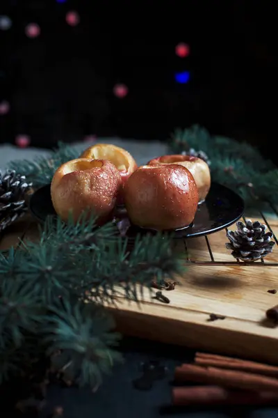 Las manzanas cocidas para un nuevo año, el abeto, los conos, las luces de año nuevo sobre el fondo negro — Foto de Stock