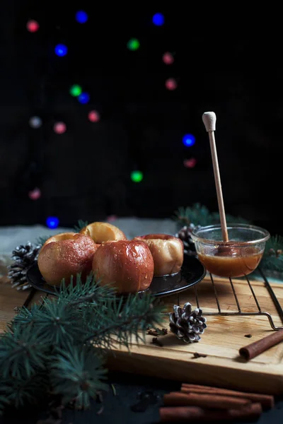 Las manzanas cocidas para un nuevo año, el abeto, los conos, la miel las luces de Año Nuevo sobre el fondo negro — Foto de Stock