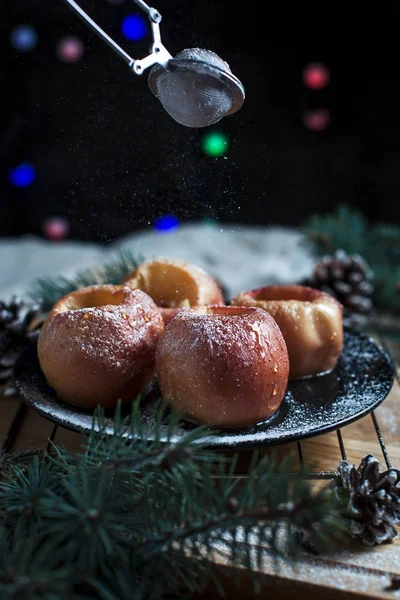 Las manzanas cocidas para un nuevo año, el abeto, los conos, las luces de año nuevo sobre el fondo negro — Foto de Stock