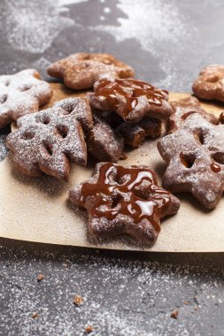 Ahşap, kesme tahtası gri bir arka plan üzerine pudra şekeri ile Noel tatlılar