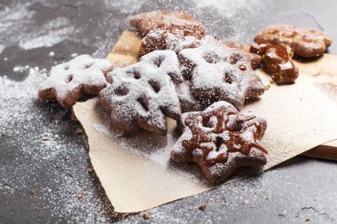 Ahşap, kesme tahtası gri bir arka plan üzerine pudra şekeri ile Noel tatlılar