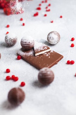 çikolata şekerleme, çikolata ve gri arka plan ve pudra şekeri kırmızı meyveler yuvarlak