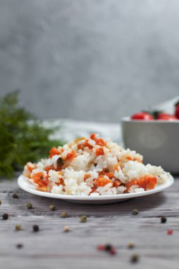 haşlanmış havuç, bezelye ve soğanlı beyaz tabakta, bıldırcın yumurtası ile lezzetli pirinç kase kiraz domates, havlu, biber ve hafif ahşap bir masa üzerine dereotu ile