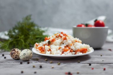 haşlanmış havuç, bezelye ve soğanlı beyaz tabakta, bıldırcın yumurtası ile lezzetli pirinç kase kiraz domates, havlu, biber ve hafif ahşap bir masa üzerine dereotu ile