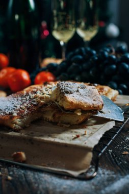 bir yeni yıl'ın tablo, peynir pasta çikolata, mandalina, üzüm, bisküvi, şampanya ve iki bardak dekore edilmiş bir Noel ağacı ışıkları ile fon karşı