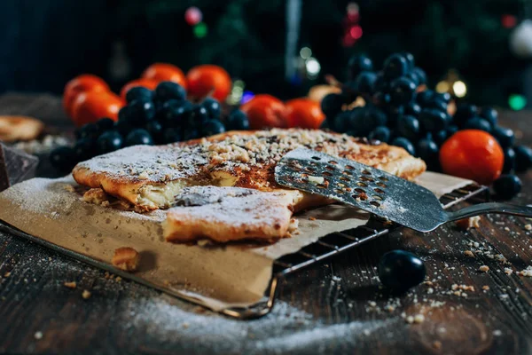 Pastel de queso con chocolate, galletas, mandarinas, uvas en una mesa de madera — Foto de Stock