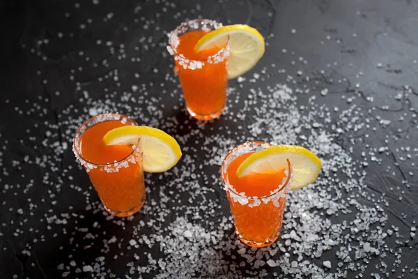 Cócteles de naranja, sal, limón sobre un fondo oscuro — Foto de Stock