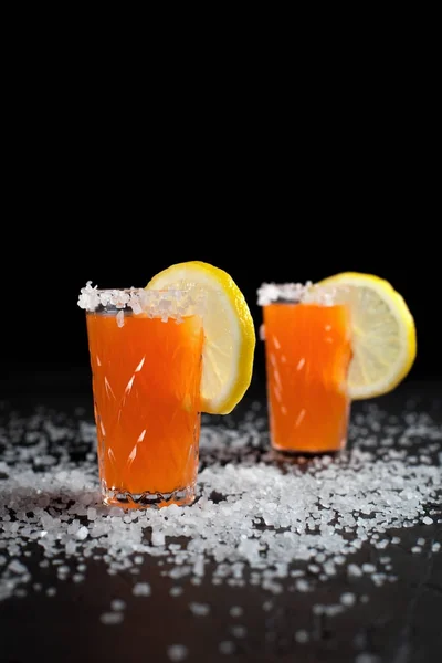 Coquetéis de laranja, sal, limão em um fundo escuro — Fotografia de Stock
