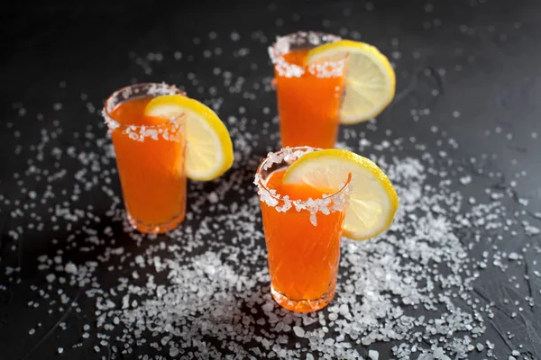 Cócteles de naranja, sal, limón sobre un fondo oscuro — Foto de Stock