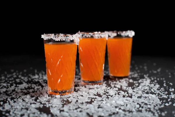 Cócteles de naranja, sal, limón sobre un fondo oscuro — Foto de Stock