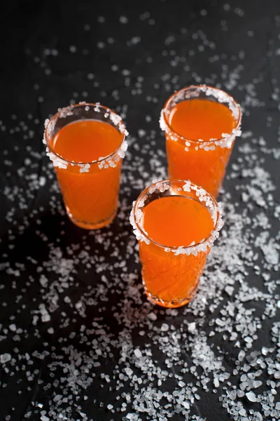 Cócteles de naranja, sal, limón sobre un fondo oscuro — Foto de Stock