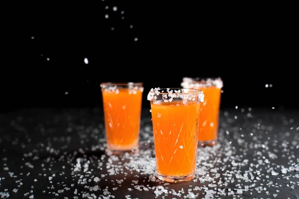 Coquetéis de laranja, sal, limão em um fundo escuro — Fotografia de Stock