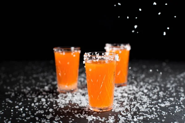 orange cocktails, salt, lemon on a dark background