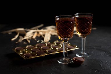 şarap, çikolata ve meyve karanlık bir arka plan üzerinde gözlük