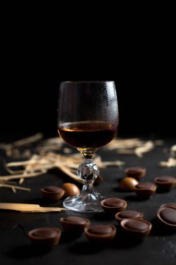 şarap, çikolata ve meyve karanlık bir arka plan üzerinde gözlük