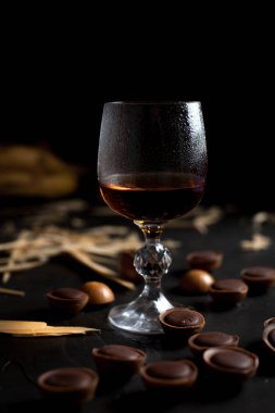 şarap, çikolata ve meyve karanlık bir arka plan üzerinde gözlük